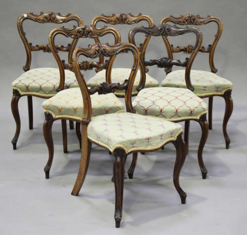 A set of six early Victorian rosewood dining chairs with carved scroll decoration