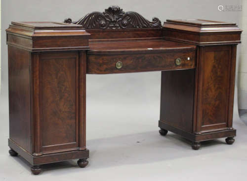 An early 19th century figured mahogany twin pedestal sideboard
