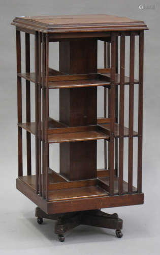 An Edwardian walnut revolving library bookcase with slatted sides