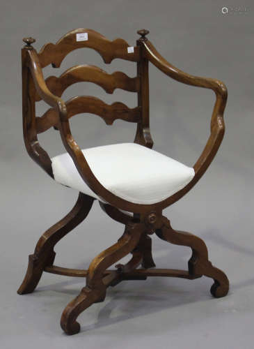 An early 20th century Savonarola style walnut armchair