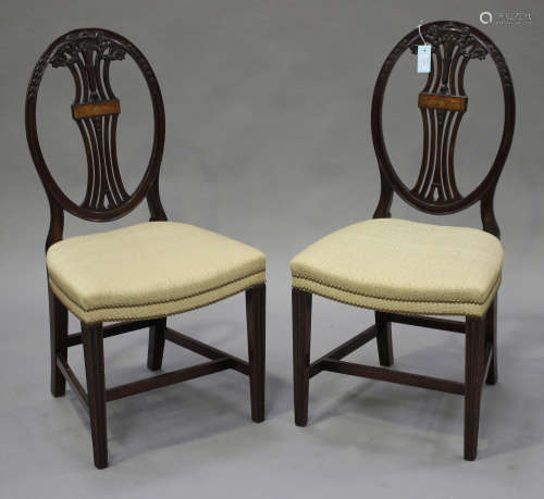 A pair of late 19th century Hepplewhite style mahogany pierced splat back dining chairs with carved urn and swag decoration
