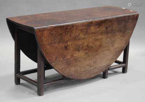 An 18th century provincial oak drop-flap oval dining table