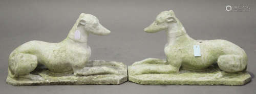 A pair of early 20th century composition stone garden figures of recumbent greyhounds