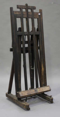 An early 20th century stained oak artist's easel with winding mechanism
