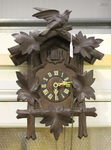 An early 20th century Black Forest softwood cuckoo clock with weight driven movement striking on a gong