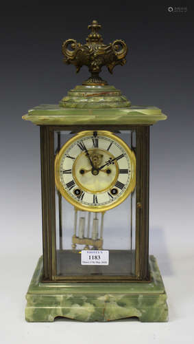 A late 19th/early 20th century American onyx and brass four glass mantel clock with eight day movement striking on a gong