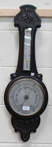 An early 20th century oak aneroid wheel barometer with mercury thermometer and silvered dials