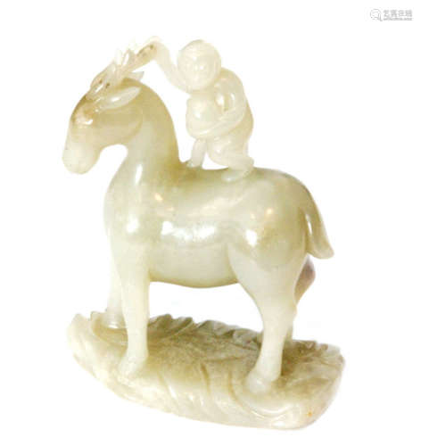 A Chinese celadon jade carving of a standing horse with a monkey standing on its back holding a gourd