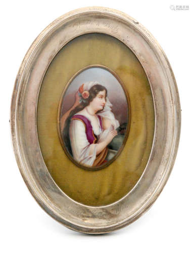 An early 20th Century small oval hand painted plaque depicting a young lady with long brown hair sat in contemplation