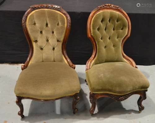 A pair of Victorian carved walnut easy chairs upholstered in pale green plush