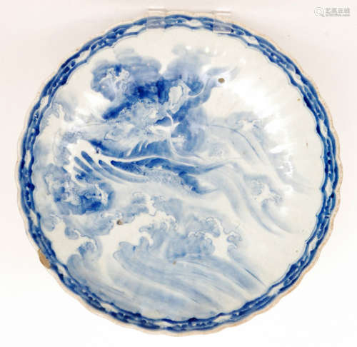 A large late 19th Century Japanese export charger decorated in blue and white with a dragon rising from the waves