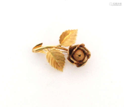 An 18ct hallmarked brooch modelled as a matt finish single flower head to a double leaf stem with scroll detail