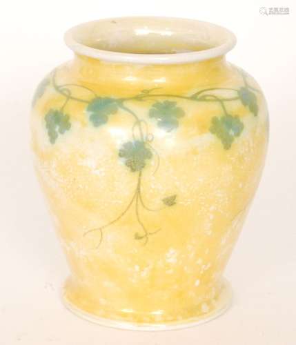 A Ruskin Pottery yellow lustre footed vase decorated with a garland of hand painted ivy to the shoulder