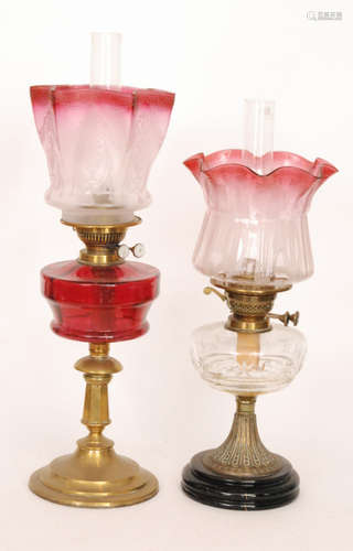 A 20th Century brass oil lamp and shade engraved with urns and swags with ruby reservoir