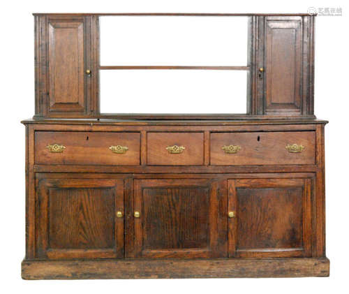 A 19th Century oak three drawer dresser base fitted with pierced brass handles on cupboard plinth base