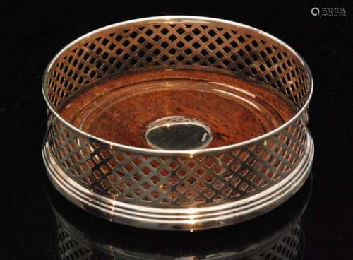 A hallmarked silver circular coaster with pierced gallery