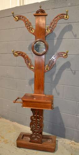 A Victorian mahogany four branch hall stand with circular central mirrored back and brass acorn terminal finials on a platform base