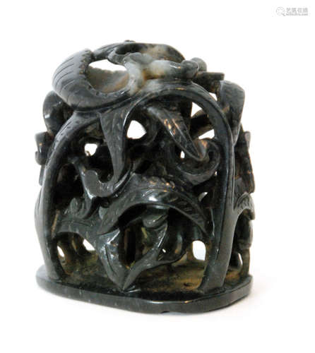 A Chinese black jade pierced and carved depiction of mythical birds eating leaves amidst scrolling vines