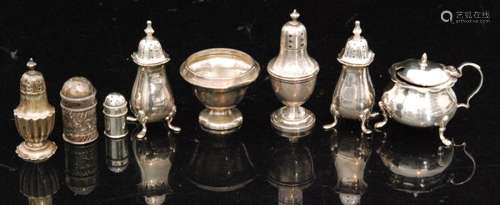 A parcel lot of hallmarked silver peppers with an open salt and a cauldron shaped covered mustard