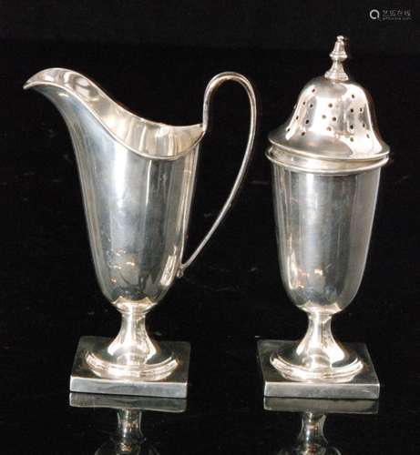 A hallmarked silver strawberry set comprising of helmet shaped cream jug on square pedestal base with matching sugar sifter