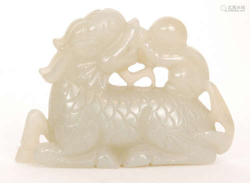 A Chinese celadon jade carving of a recumbent dragon or qilin with carved scaly body