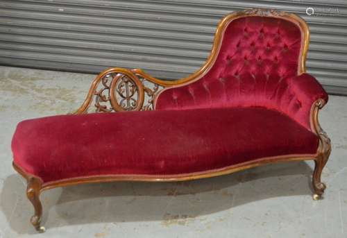 A Victorian carved mahogany framed chaise longue upholstered in crimson buttoned back plush