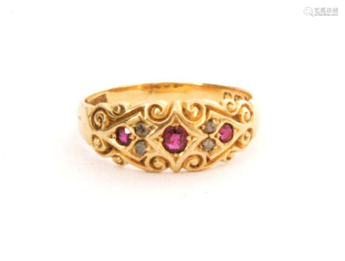 An early 20th Century 18ct hallmarked boat shaped seven stone ruby and diamond ring with scroll details to shaped head