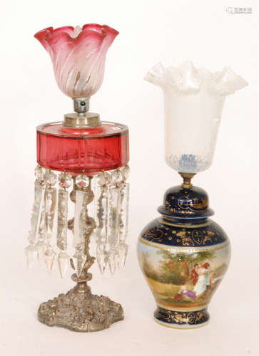 A Victorian drop lustre oil lamp with ruby glass reservoir on plated rococco style base