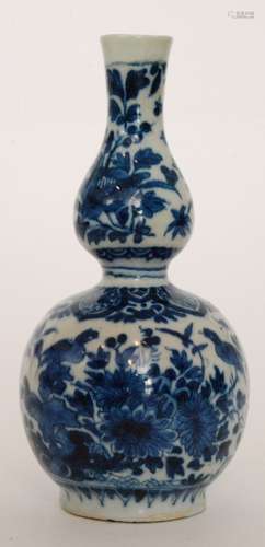 A late 19th Century continental double gourd vase decorated in blue and white with birds and foliage