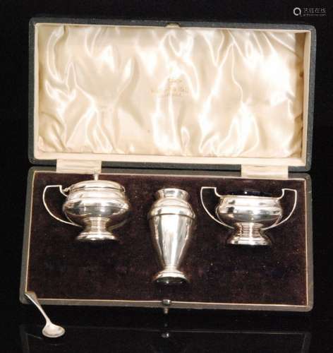 A hallmarked silver cased three piece pedestal cruet set of plain form