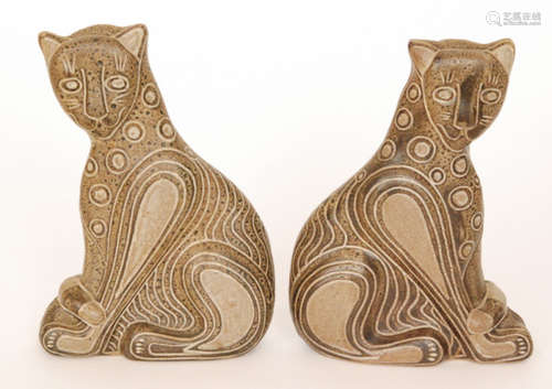 A pair of later 20th Century studio pottery models of seated leopards