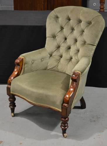 A Victorian mahogany framed easy chair upholstered in green buttoned back plush