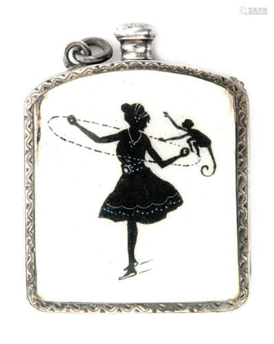 A hallmarked silver cushioned rectangular vesta strike with black enamelled decoration of a female ice skater and a monkey to a cream coloured ground