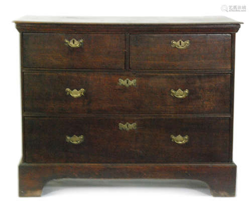 A George III oak straight front chest of two short and two long drawers fitted with brass drop handles