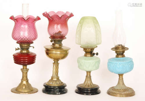 Two Victorian oil lamps each with cranberry shades