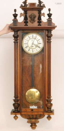 A late 19th Century eight day strike single weight regulator wall clock with Roman numerals to a circular dial behind glazed door and below architectural pediment