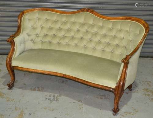 A Victorian carved walnut two seat settee with buttoned down pale green upholstery