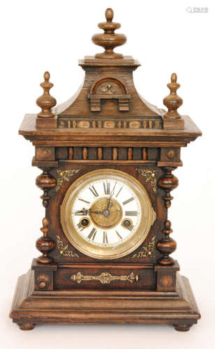 An early 20th Century oak eight day strike mantle clock Roman numerals to a white dial below a pagoda style top