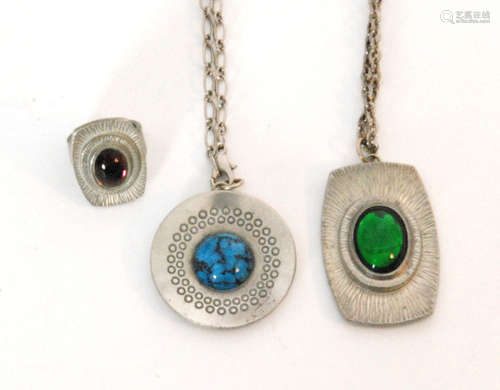 Two Danish pewter pendants by Jorgen Jensen to include a circular concave pendant inset with a turquoise style cabochon