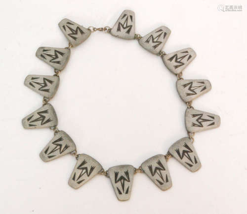 A 1950s Danish pewter necklace designed as fourteen panels each decorated with an Aztec Frog motif