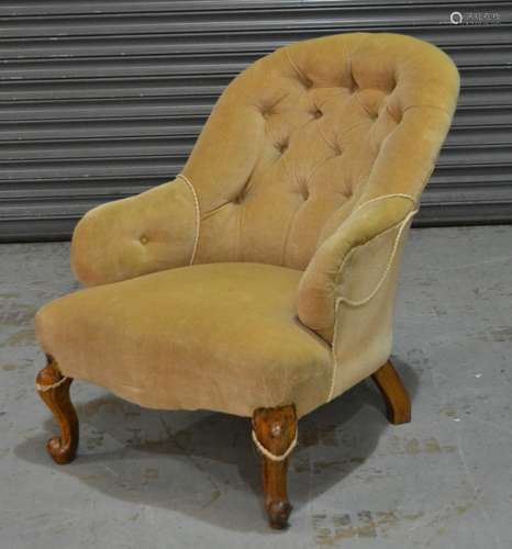 A Victorian easy chair with oatmeal coloured button down upholstery over walnut scroll carved cabriole legs