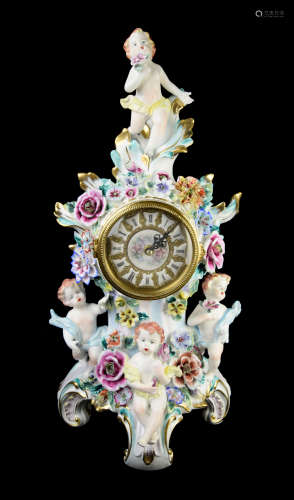 A Continental Porcelain Clock with Four Cherubs and Flowers