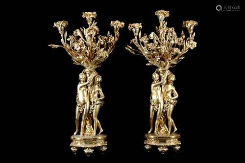 A PAIR OF 19TH CENTURY FRENCH GILT BRONZE FIGURAL CANDELABRA AFTER THE MODEL BY ETIENNE-MAURICE FALCONET CIRCA 1760each modelled as a pair of nude classical maidens holing aloft a large arrangement of flowers tied with a floral garland and drapery which tumbles to the shaped bases