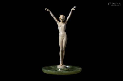 A FRENCH ART DECO PERIOD CARVED IVORY FIGURE OF A NUDE GIRL CIRCA 1920the standing figure with both arms raised