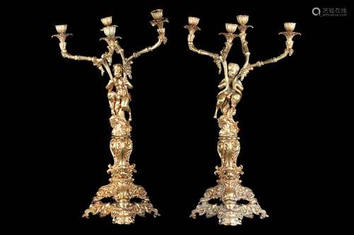 A PAIR OF EARLY 20TH CENTURY GILT METAL FIGURAL CANDELABRA IN THE MANNER OF CLODION each modelled as a youthful satyr holding aloft four branches terminating in stiff-leaf cast nozzles