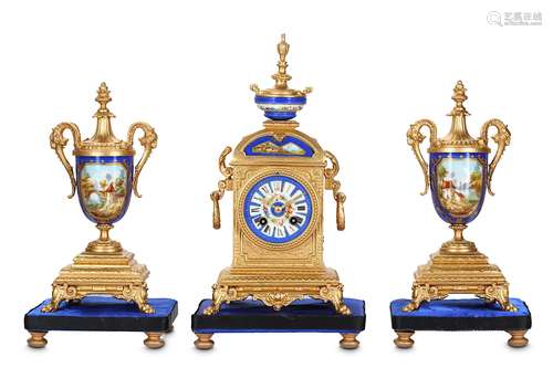 A 19TH CENTURY FRENCH GILT METAL AND PORCELAIN MOUNTED CLOCK GARNITURE the arched case surmounted by an urn and with a pair of ring handles to the sides