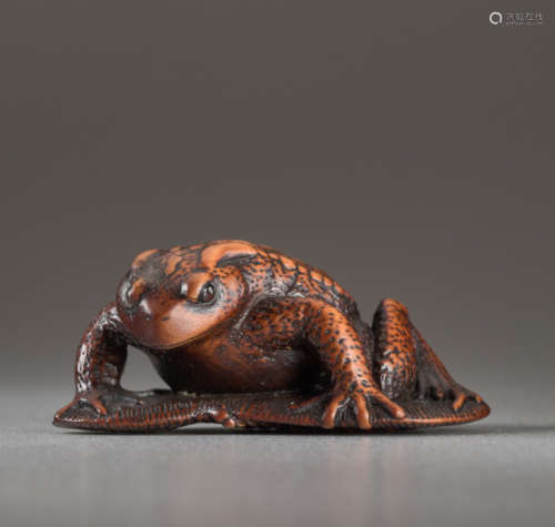 A WOOD NETSUK E BY TANRI OF A TOAD ON A SANDALW...