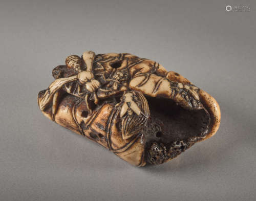 A STAG ANTLER NETSUKE BY SHUNMIN OF A LOTUS LEAF A...