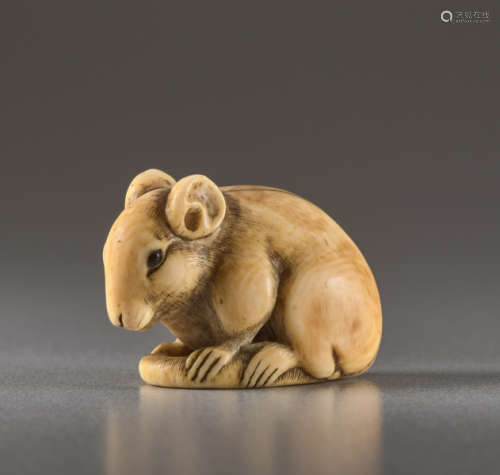 AN IVORY NETSUKE BY IKKO OF A SEATED RATIvory n...