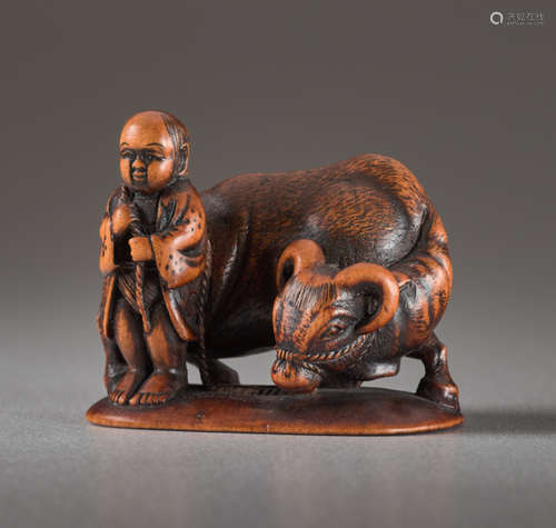 A WOOD NETSUKE BY MINKOKU OF A BOY AND OXWood n...